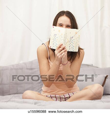 Young woman reading diary on bed, laughing View Large Photo Image Stock Photo - Young woman reading diary on bed, laughing. Fotosearch