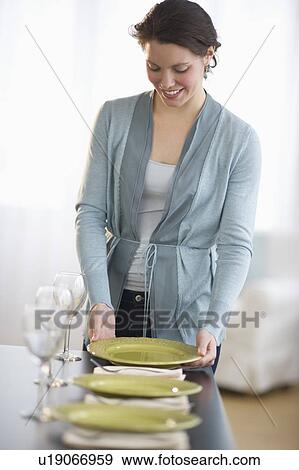 Young woman setting table View Large Photo Image Stock Photo - Young woman setting table. Fotosearch
