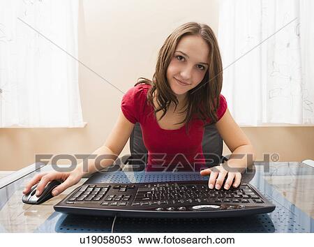Young woman working on computer View Large Photo Image Stock Image - Young woman working on computer. Fotosearch