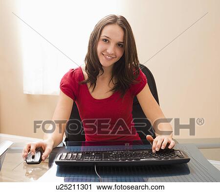 Stock Image - Young woman working on computer. Fotosearch