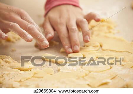 Picture - Young womans hands kneading cookie dough. Fotosearch