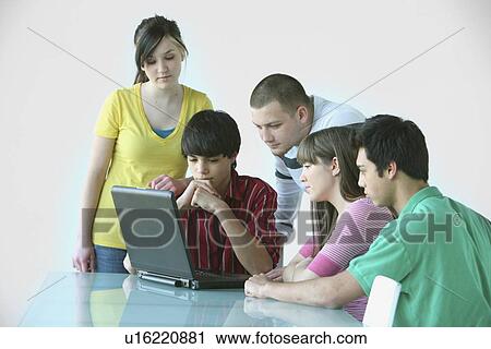 a group of teenagers gathered around a laptop computer; troutdale, oregon, united states of america View Large Photo Image Stock Image - a group of teenagers gathered around a laptop computer; troutdale, oregon, united states of america. Fotosearch