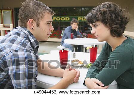 a young couple in a fight as a young man looks on; troutdale, oregon, united states of america View Large Photo Image Stock Image - a young couple in a fight as a young man looks on; troutdale, oregon, united states of america. Fotosearch
