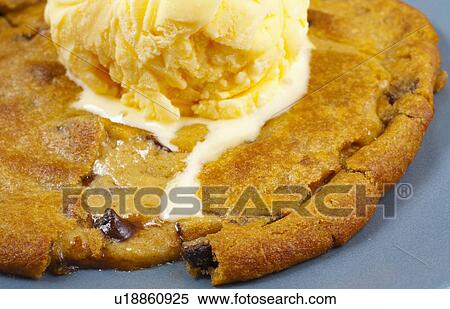 Stock Photography - Ice Cream Melting On Top Of A Cookie. Fotosearch