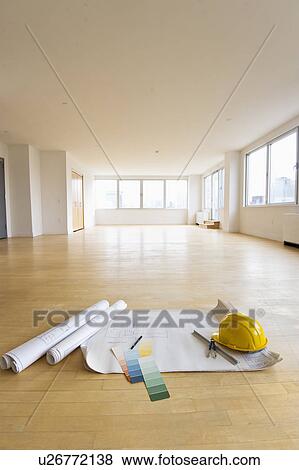 Stock Photo - Blueprint, color swatch and hardhat on floor in empty room. Fotosearch