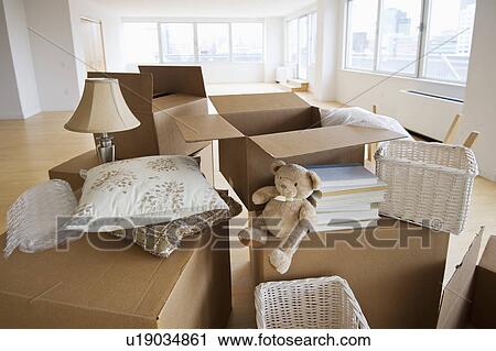 Stock Image - Boxes and decors stacked in room. Fotosearch