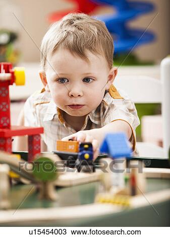 Boy (2-3) playing with toy train View Large Photo Image Stock Image - Boy (2-3) playing with toy train. Fotosearch