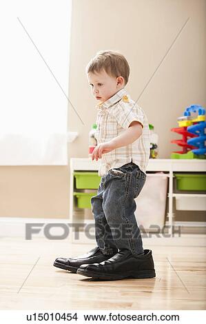 Picture - Boy (2-3) walking in dad's shoes. Fotosearch