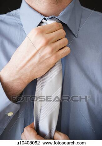 Stock Image - Businessman adjusting tie. Fotosearch