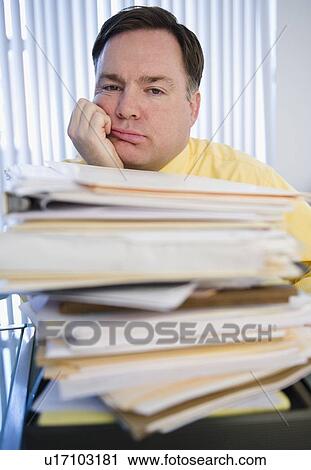 Businessman behind stack of paperwork View Large Photo Image Stock Image - Businessman behind stack of paperwork. Fotosearch