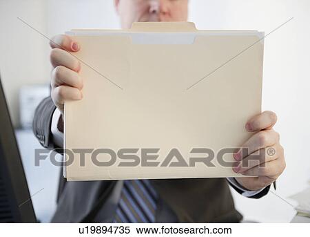 Stock Photography - Businessman holding folder. Fotosearch