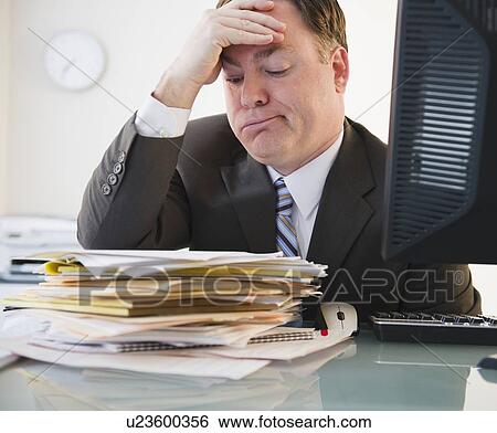 Businessman looking at stack of folders View Large Photo Image Stock Photograph - Businessman looking at stack of folders. Fotosearch