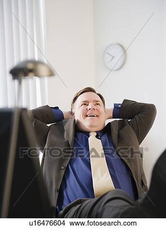 Businessman relaxing in office View Large Photo Image Picture - Businessman relaxing in office. Fotosearch