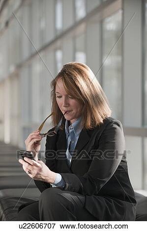 Stock Photo - Businesswoman text-messaging. Fotosearch