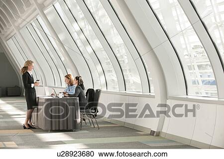 Businesswomen talking at desk in corridor View Large Photo Image Stock Image - Businesswomen talking at desk in corridor. Fotosearch