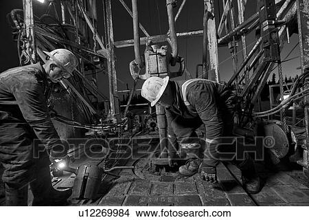 Canada, Alberta, Oil workers using oil drill View Large Photo Image Picture - Canada, Alberta, Oil workers using oil drill. Fotosearch