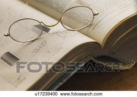 Close up of antique glasses lying on open book View Large Photo Image Stock Image - Close up of antique glasses lying on open book. Fotosearch