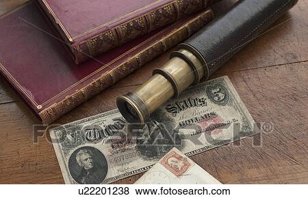 Close up of antique telescope, books and banknote View Large Photo Image Stock Photo - Close up of antique telescope, books and banknote. Fotosearch