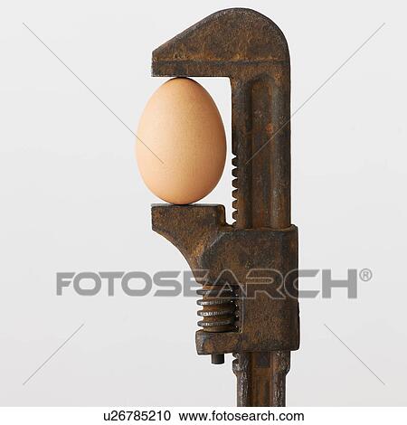 Stock Image - Close up of egg in rusty wrench. Fotosearch