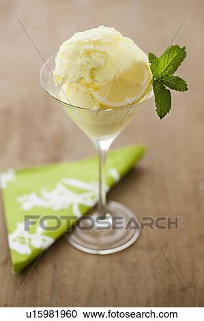 Stock Image - Close up of ice cream with mint leaf and lemon slice. Fotosearch