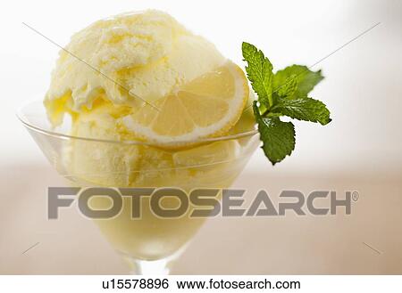 Stock Photograph - Close up of ice cream with mint leaf and lemon slice. Fotosearch
