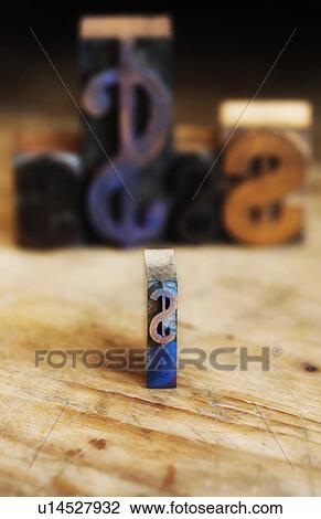 Stock Image - Close up of printing blocks with dollar sign with defocused background. Fotosearch