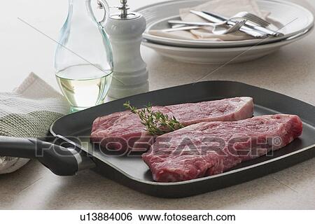 Close up of raw steak on frying pan View Large Photo Image Stock Photograph - Close up of raw steak on frying pan. Fotosearch
