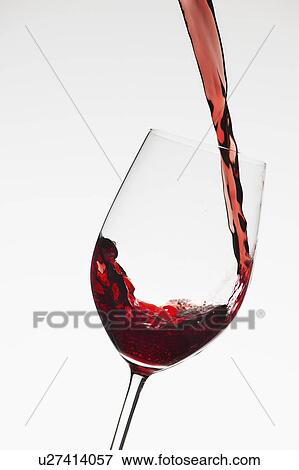 Close up of red wine being poured into glass on white background View Large Photo Image Stock Photo - Close up of red wine being poured into glass on white background. Fotosearch