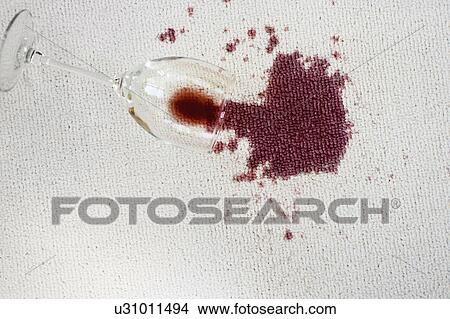 Picture - Close up of spilled red wine on white carpet. Fotosearch