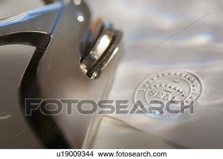 Picture - Close up of stamper and corporate seal on paper. Fotosearch