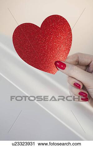 Close up of woman's fingers with red nail polish holding red heart View Large Photo Image Stock Image - Close up of woman's fingers with red nail polish holding red heart. Fotosearch