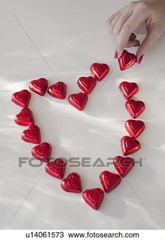 Close up of woman's hand with red nail polish making heart shape from chocolates View Large Photo Image Stock Image - Close up of woman's hand with red nail polish making heart shape from chocolates. Fotosearch
