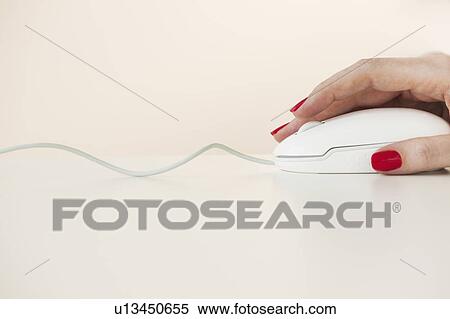 Stock Photography - Close up of woman's hand with red nail polish holding computer mouse. Fotosearch