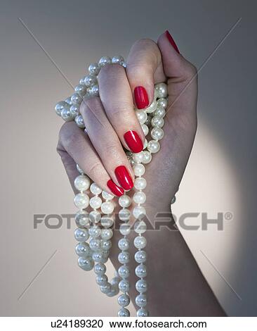 Close up of woman's hands with red nail polish holding pearls View Large Photo Image Stock Image - Close up of woman's hands with red nail polish holding pearls. Fotosearch