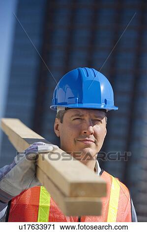 Construction worker carrying planks View Large Photo Image Stock Image - Construction worker carrying planks. Fotosearch