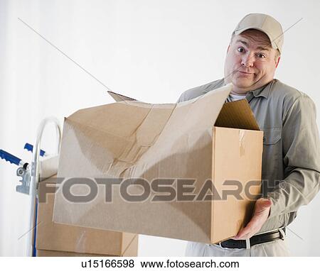Delivery man holding damaged box View Large Photo Image Stock Photo - Delivery man holding damaged box. Fotosearch