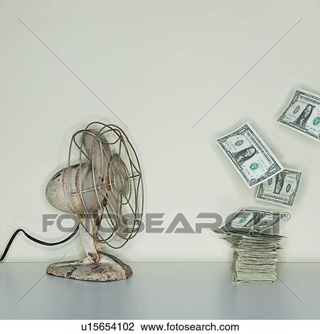 Stock Image - Electric fan blowing on heap of dollar banknotes. Fotosearch