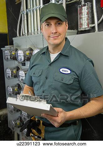 Stock Image - Electrician controlling electric meters. Fotosearch