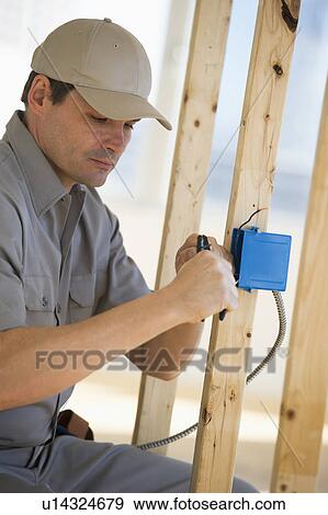 Stock Photo - Electrician working at construction site. Fotosearch