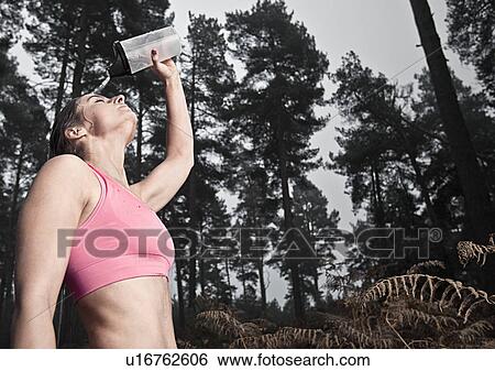 England, Suffolk, Female athlete pouring water on head, Thetford Forest View Large Photo Image Stock Photograph - England, Suffolk, Female athlete pouring water on head, Thetford Forest. Fotosearch