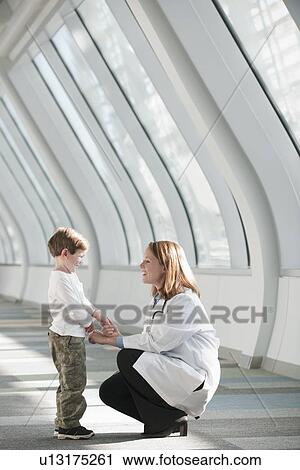 Female doctor talking to boy (6-7) in corridor View Large Photo Image Stock Image - Female doctor talking to boy (6-7) in corridor. Fotosearch