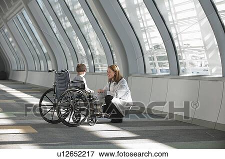 Female doctor talking to boy (6-7) in wheelchair View Large Photo Image Stock Photo - Female doctor talking to boy (6-7) in wheelchair. Fotosearch