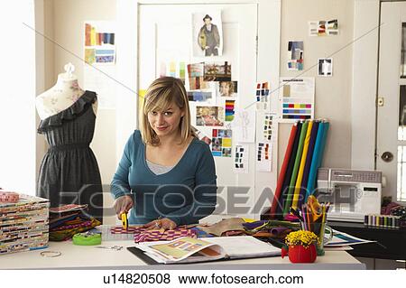 Stock Photo - Female fashion designer working in studio. Fotosearch