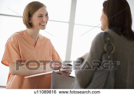 Stock Photograph - Female nurse talking with patient. Fotosearch