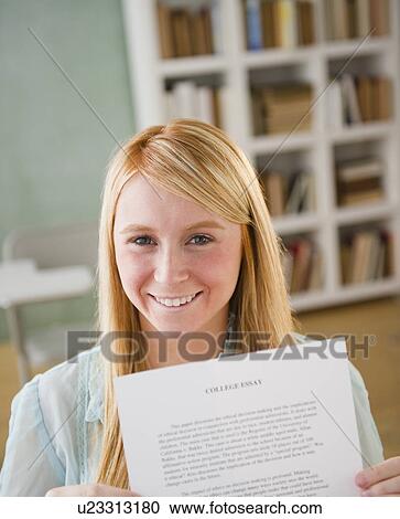 Stock Image - Female student showing essay. Fotosearch