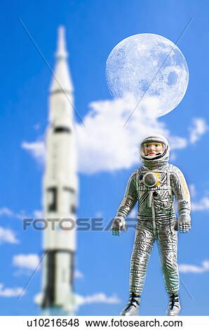 Figurine of astronaut with rocket in background View Large Photo Image Stock Photo - Figurine of astronaut with rocket in background. Fotosearch