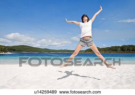 Stock Photo - Fraser Island, Australia, Woman cheering on beach. Fotosearch