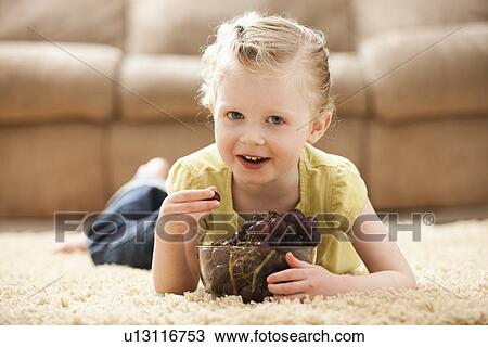 Girl (2-3) lying on floor eating grapes View Large Photo Image Stock Image - Girl (2-3) lying on floor eating grapes. Fotosearch