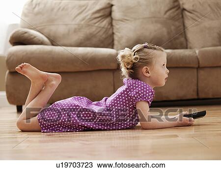 Girl (2-3) lying on floor, watching TV View Large Photo Image Stock Image - Girl (2-3) lying on floor, watching TV. Fotosearch