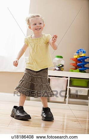 Girl (2-3) walking in dad's shoes View Large Photo Image Stock Photo - Girl (2-3) walking in dad's shoes. Fotosearch